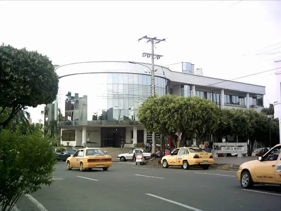 Avenida con taxis frente a un edificio moderno de vidrio