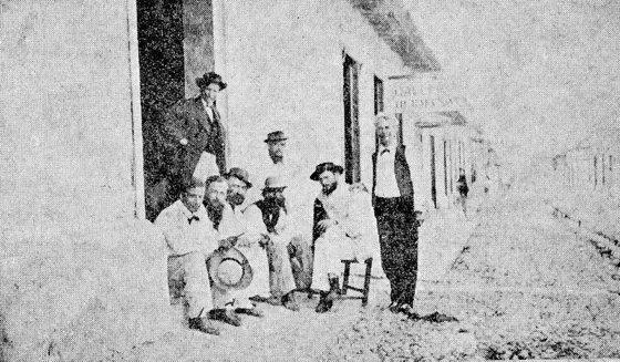 Calle del Comercio en el almacén de Gallegos Hnos., aparecen varios personajes populares de la ciudad, que usualmente hacían sus tertulias en las aceras frente a sus casas o establecimientos comerciales. Fuente: Cámara de Comercio de Cúcuta.