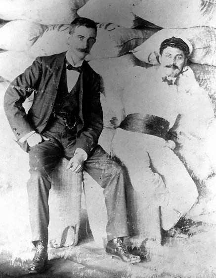 Rodolfo Faccini y Tito Abbo, destacados comerciantes de origen Italiano, que tuvieron gran influencia en la vida comercial de Cúcuta, durante las primeras décadas del siglo XX. Aparecen fotografiados sobre varios sacos de café, que era el principal producto de exportación. 1902.