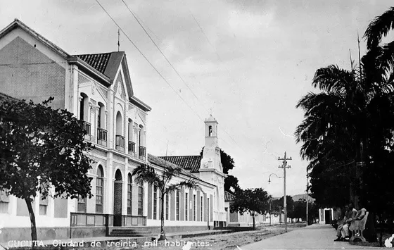 Hospital San Juan de Dios y al fondo la Capilla del carmen. Década del 20. Avenida 2 entre calles 12 y 13. Actualmente en su lugar se encuentra La Biblioteca Departamental Luís Pérez Ferrero y la labor desempeñada por el Hospital San Juan de Dios la realiza ahora el Hospital Erasmo Meoz. La Capilla del Carmen si ha permanecido en su lugar de origen.