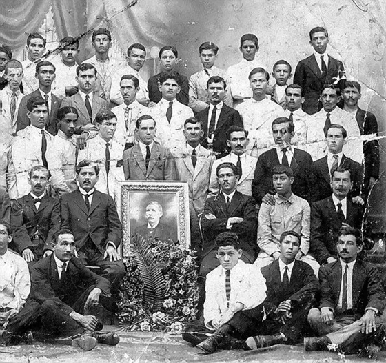 Personal de la zapateria Bota Negra de Don Ramón Pelayo, quien aparece en la fotografía enmarcada. 1924. Esta zapatería fue una de las empresas manufactureras mas pujantes de Cúcuta, pués fueron los pioneros de la industria del calzado, renglón que aún tiene tradición e importancia en el desarrollo empresarial de Cúcuta. Calle 10 entre avenidas 6 y 7.