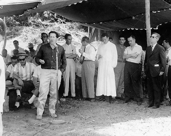 Visita del Ministro Agricultura Virgilio Barco Vargas a la zona de riego del Zulia. En el micrófono se observa a Gustavo Lozano cárdenas y al fondo el padre Camilo torres, Enrique Peñaloza y a la derecha el ministro de agricultura, Virgilio Barco Vargas. Década del 60.