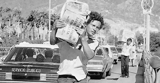 Un maletero cruza el Puente Simón Bolívar después de la crisis de la devaluación del Bolívar en 1983, cuando se incrementó el comercio informal en la ciudad.