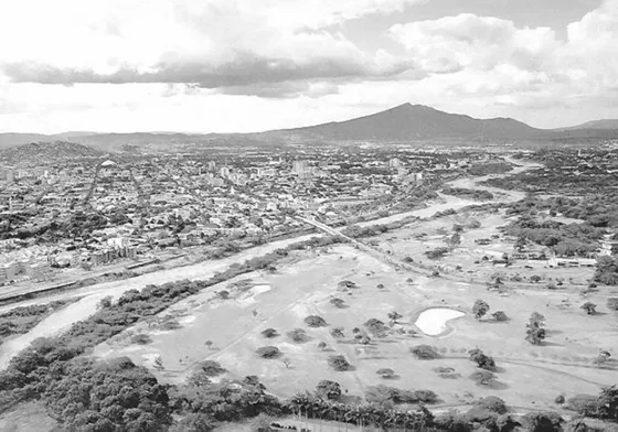 Panoramica de Cúcuta. Se observa en primer plano los terrenos del Club Tennis, el Río Pamplonita y la ciudad que se extiende en el horizonte y al fonde el Cerro de Tasajero. Década del 90.
