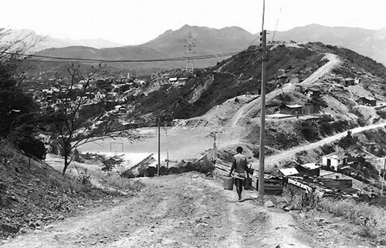 Vía sin pavimentación en uno de los barrios de invasión que dominan los cerros occidentales de la ciudad en las inmediaciones de la ciudadela Juan Atalaya. Foto, década de los 90.