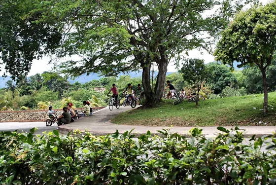 Familias en bicicleta por un sendero del parque junto al río