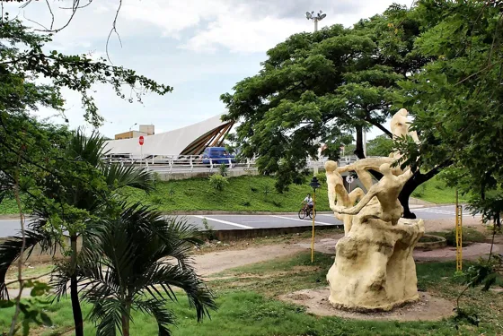 Escultura en el parque, con cubiertas de lona al fondo