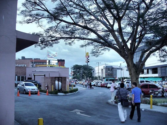 Peatones cruzando cerca de un restaurante de comida rápida