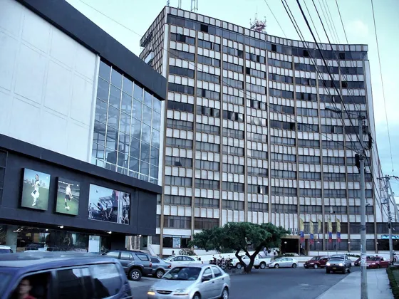 Edificio comercial de vidrio junto a un edificio alto de oficinas