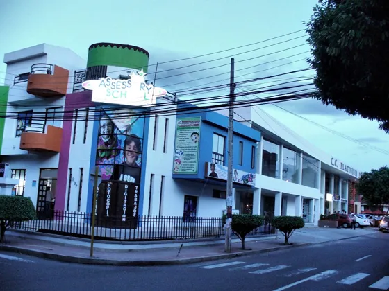 Edificio de colores con avisos comerciales en una esquina