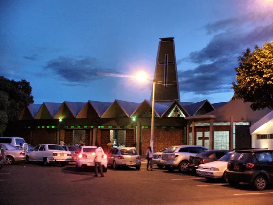 Iglesia de techos triangulares y torre al anochecer