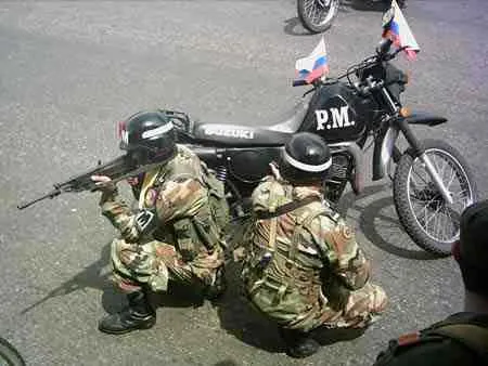 Policía Militar en posición de tiro junto a su motocicleta