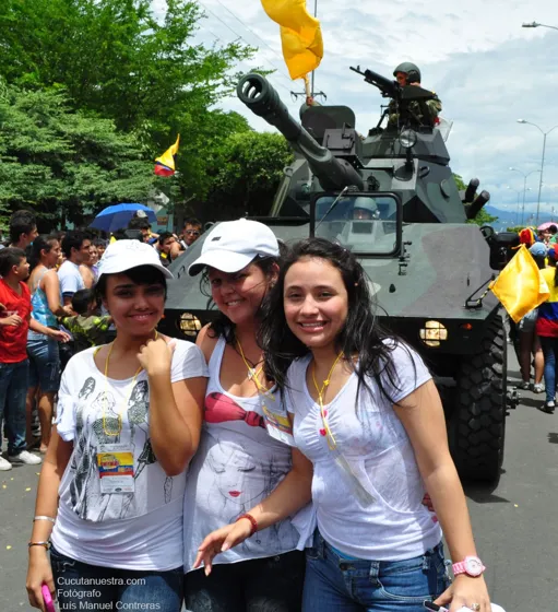 Jóvenes posando frente a una tanqueta