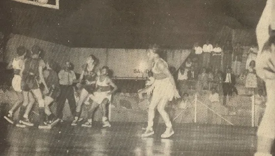 Augusto López Nº 6 de Atlantico convierte 2 puntos en el juego contra Norte, Roque Peñaloza Nº 14, Pipo Gómez Nº 10 y Joves Nº 6 de Norte observan impotentes. El árbitro portorriqueño Eladio Moreno atento a la jugada. Al fondo se observa el automovil de Pacho Unda gran aficionado al deporte a pesar de su parálisis. Este partido entre Norte y Atlántico se celebró el 10 de diciembre de 1954 en Cúcuta
