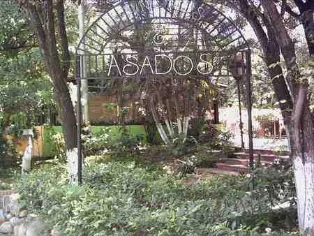 Entrada con arco metálico de un restaurante de asados