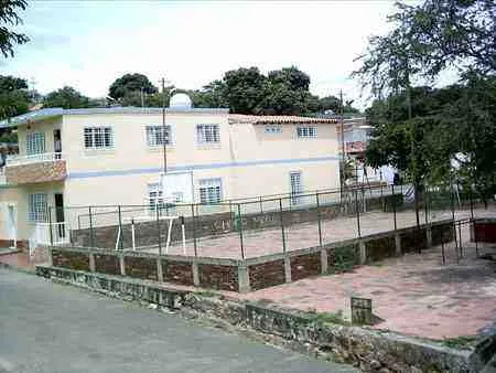 Cancha deportiva enmallada junto a una casa