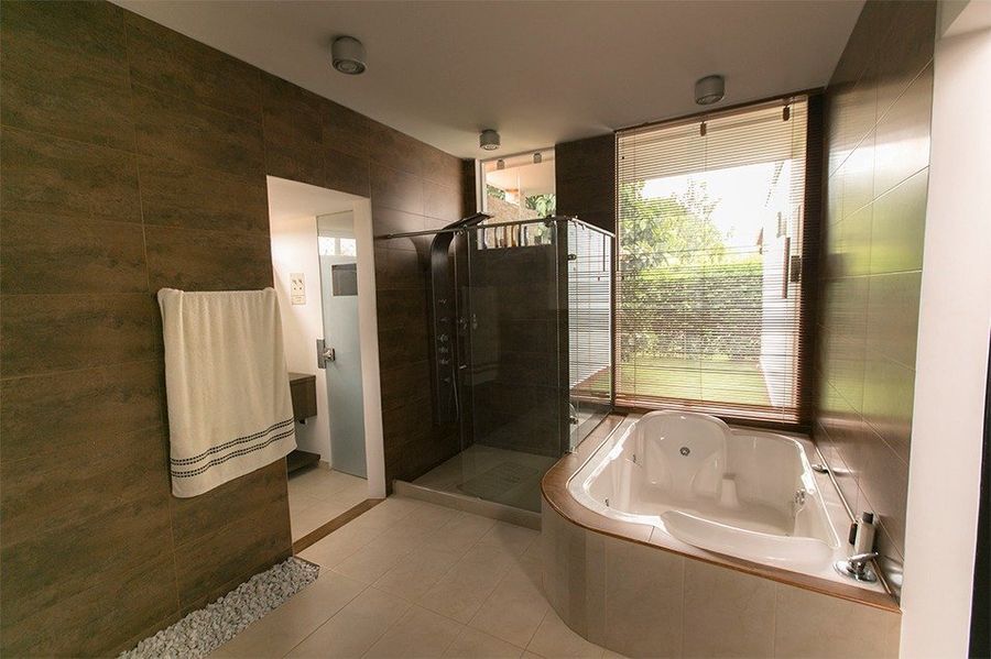 Baño principal con jacuzzi y ducha con vista al jardín