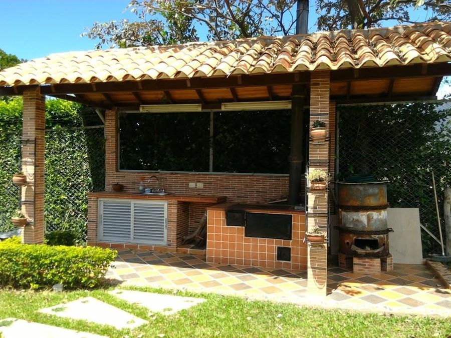 Cocina de leña exterior bajo kiosco con teja de barro