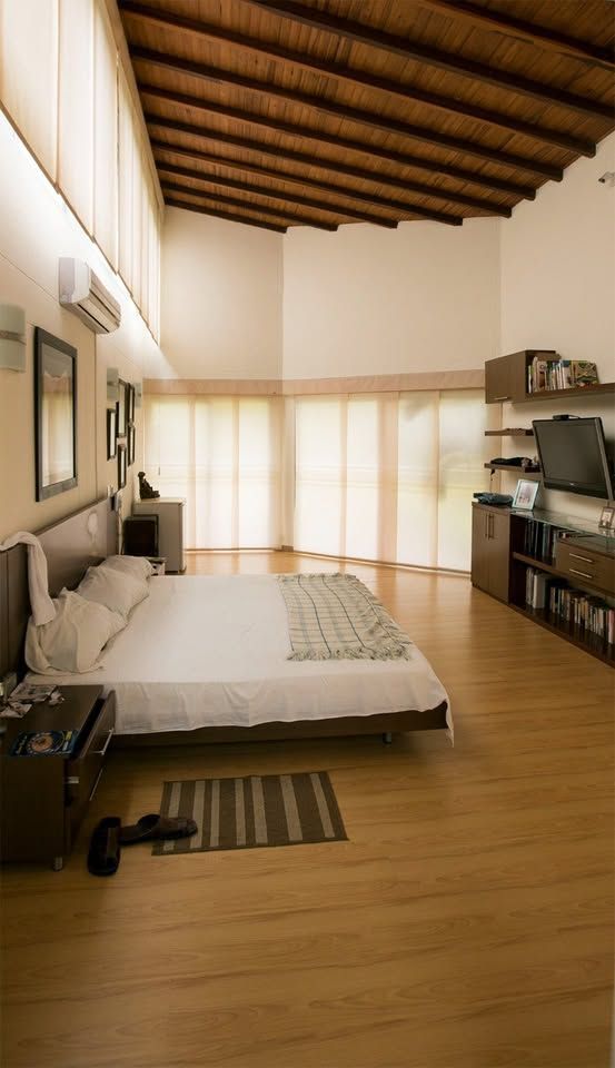 Habitación principal amplia con techo en madera y piso laminado