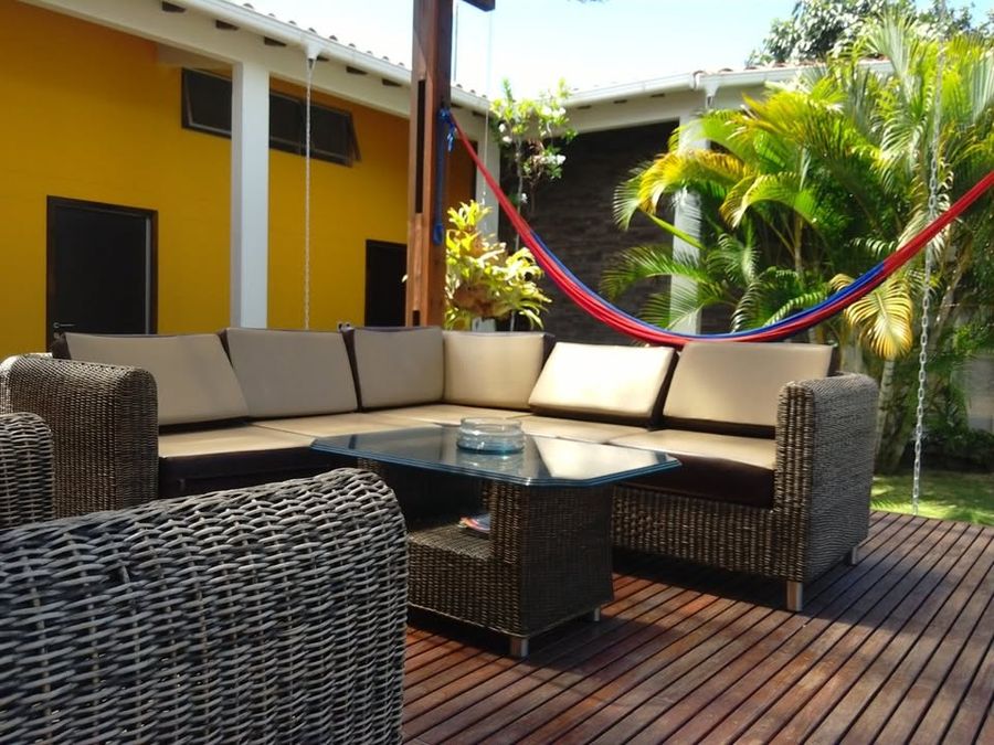 Terraza en deck de madera con muebles de exterior y hamaca